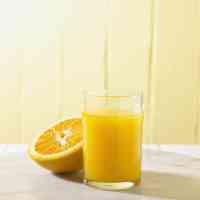 halved orange with glass of orange juice