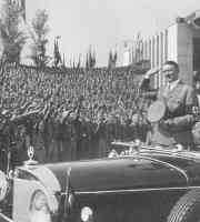 hitler in a mrecades in front of large crowd