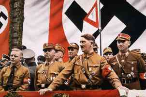 hitler orating in front of large swastika