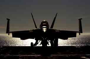 jet fighter waiting on airecraft carrier at dusk